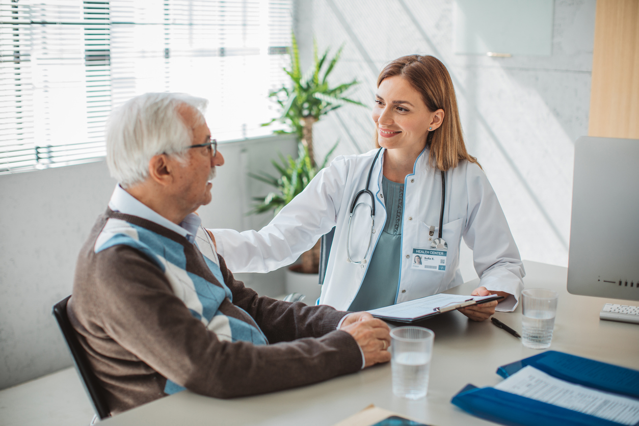 Ärztin bespricht mit einem älteren Patienten seine medizinische Vorsorge