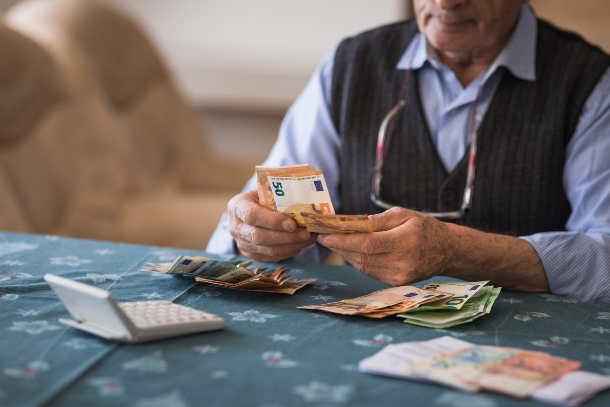 Senior zählt Geld für seine finanzielle Vorsorge und das Schonvermögen im Alter